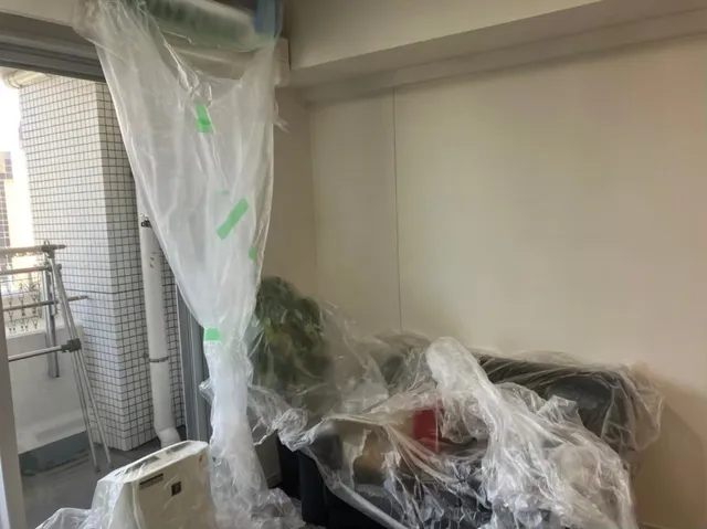 室内機と近接する家具・床をビニールで養生し、洗浄水の飛散を防ぐ準備をした様子