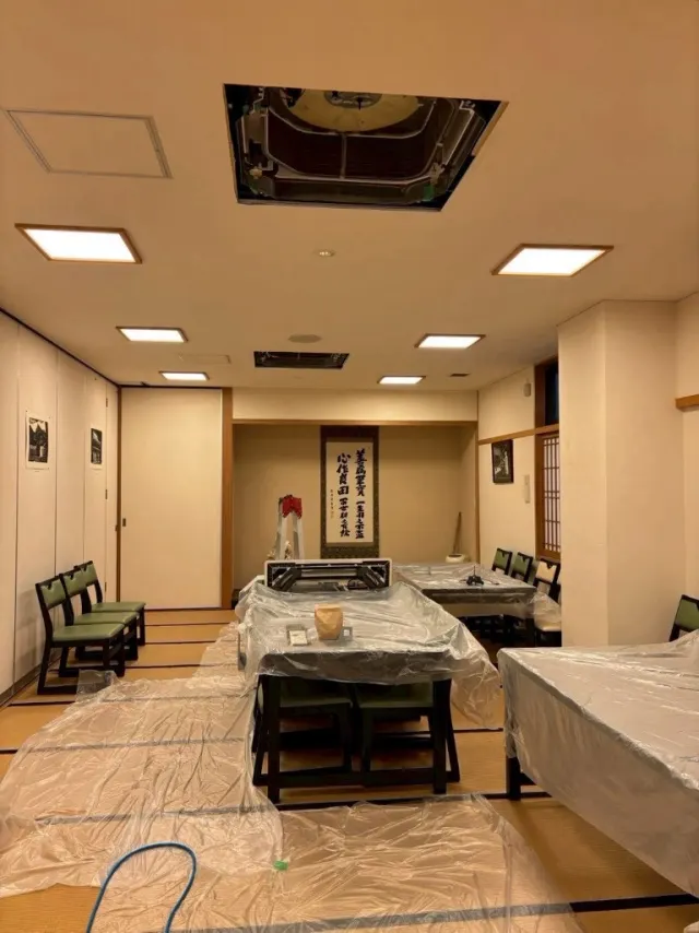 寺院の和室で畳と調度を養生し、天カセのパネルを外した様子